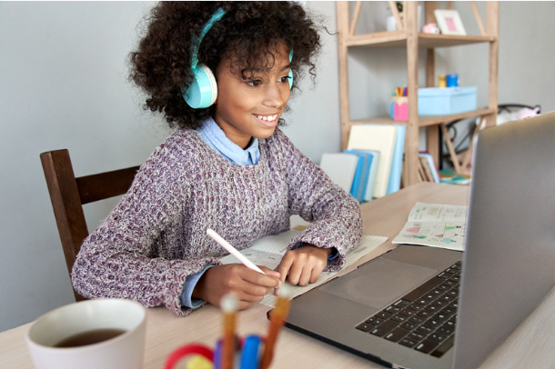 student with headphones in front of laptop